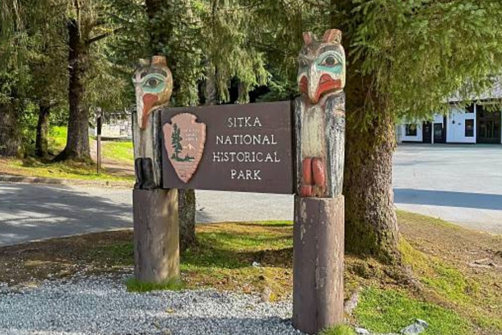 Sitka National Historical Park entrance sign with carved totem bird posts
